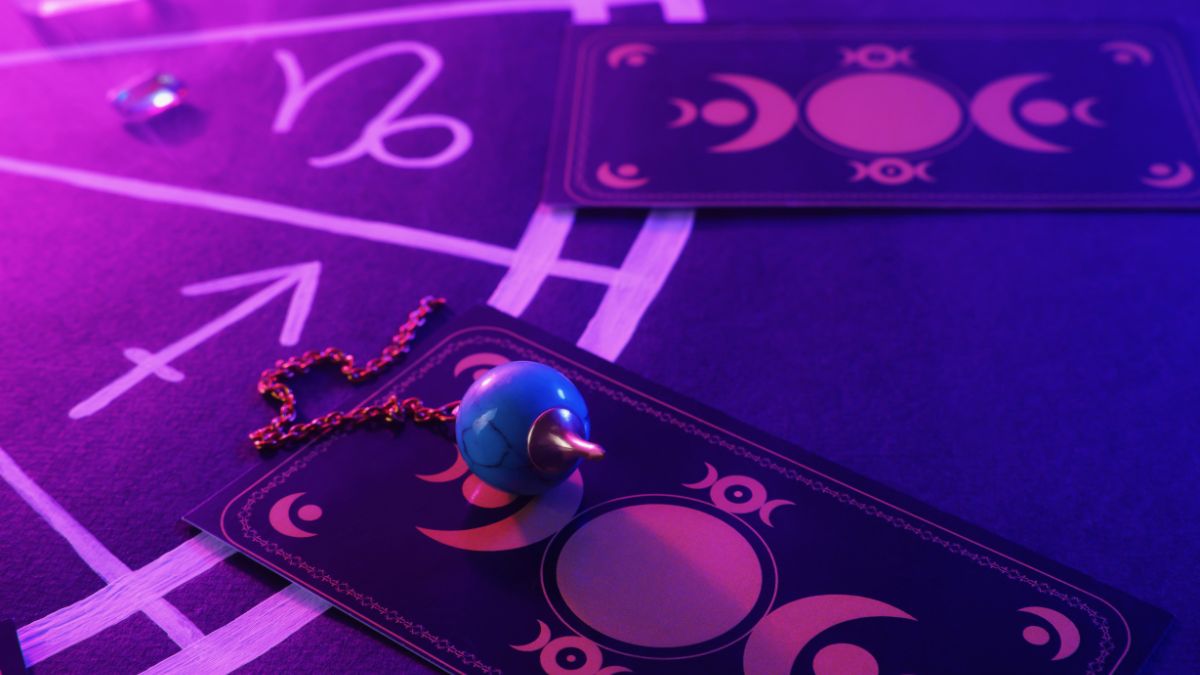 Tarot kártyák és egy pendulum, a Nyilas csillagjegy szimbólumával.