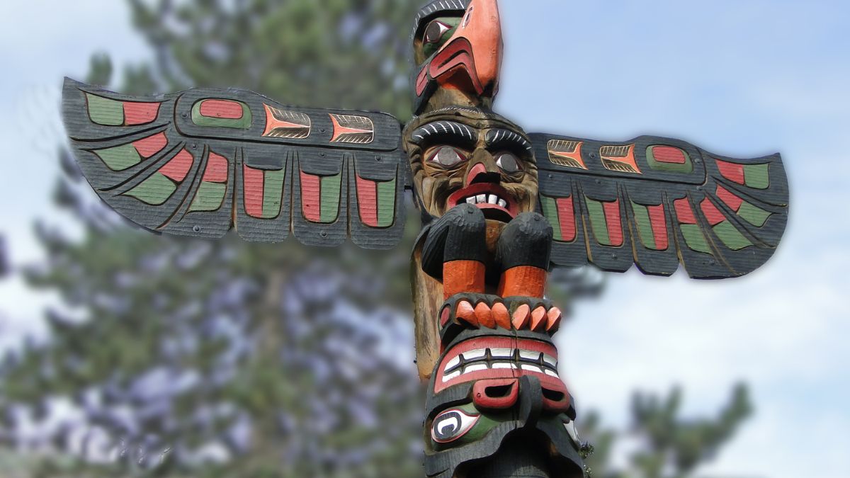 Mi a Te totemállatod? Színes totemoszlop, amely különböző állatokat és arcokat ábrázol, a természet szellemiségét tükrözi.